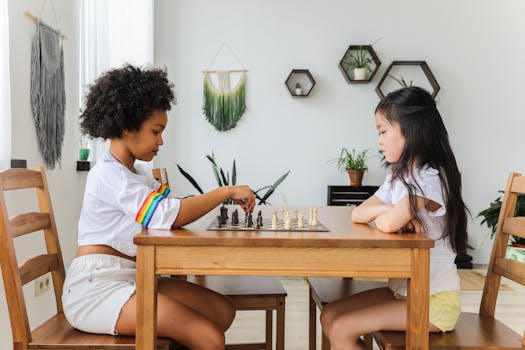 Two diverse children playing chess, focusing intently in a cozy, modern room.