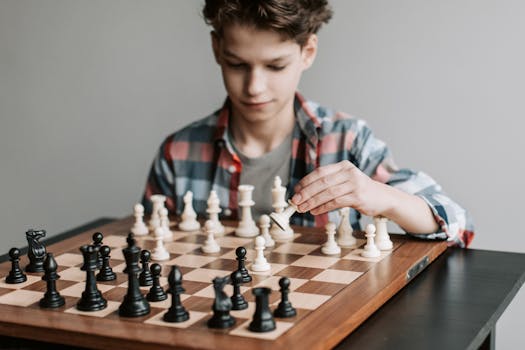 A young boy focused on playing a chess game indoors, showcasing strategy and intelligence.